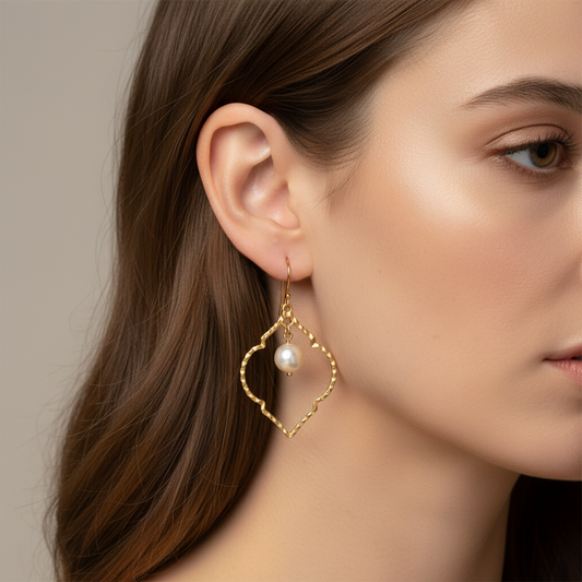 Cose E Bijoux Dalila earrings featuring a gold-plated textured frame and a central white Mallorca pearl on a model