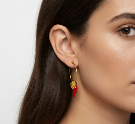 Cose E Bijoux Zagara gold hoop earrings with a red enamel horn charm and a small engraved heart pendant on a model
